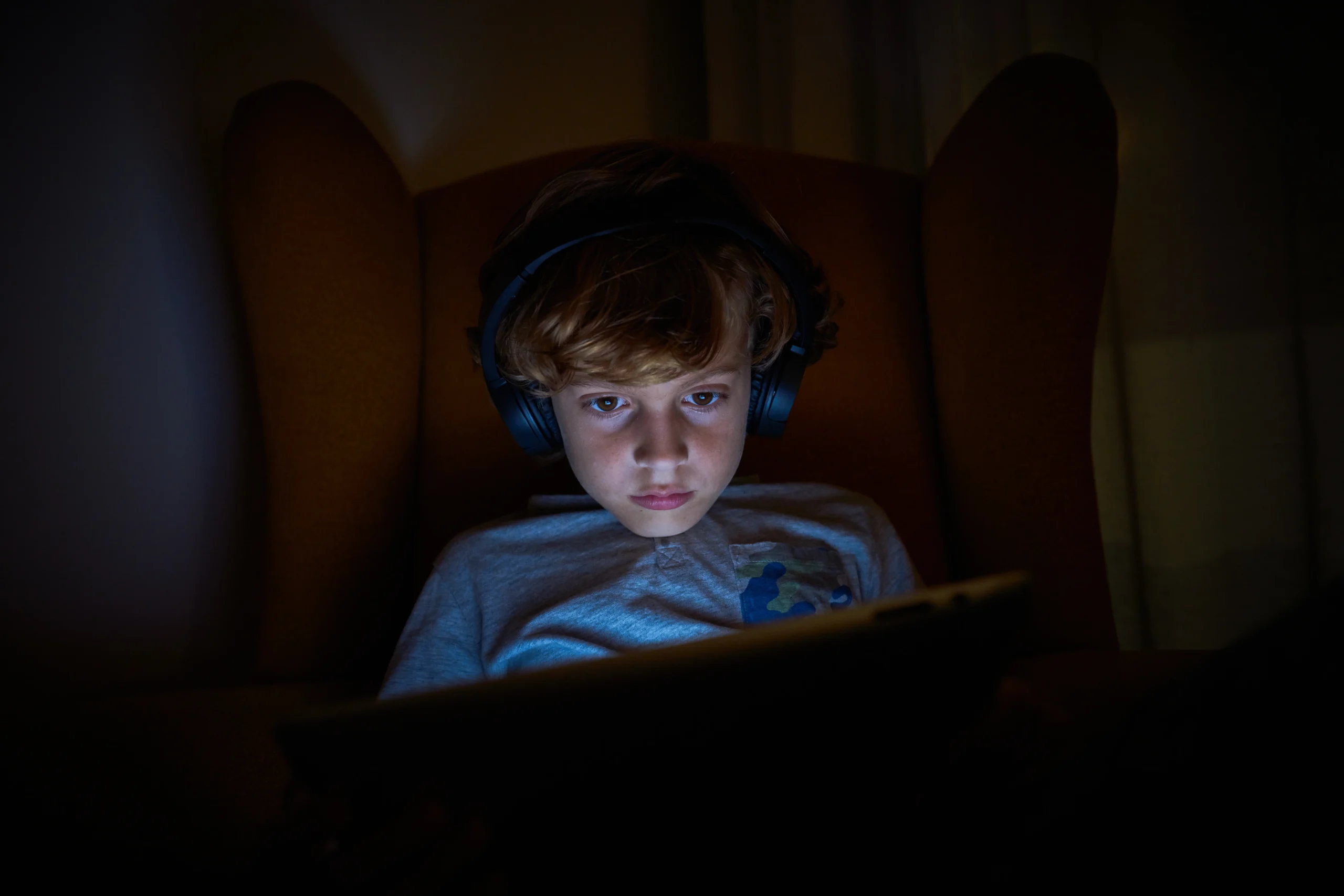 boy-playing-on-tablet-in-obscure-room